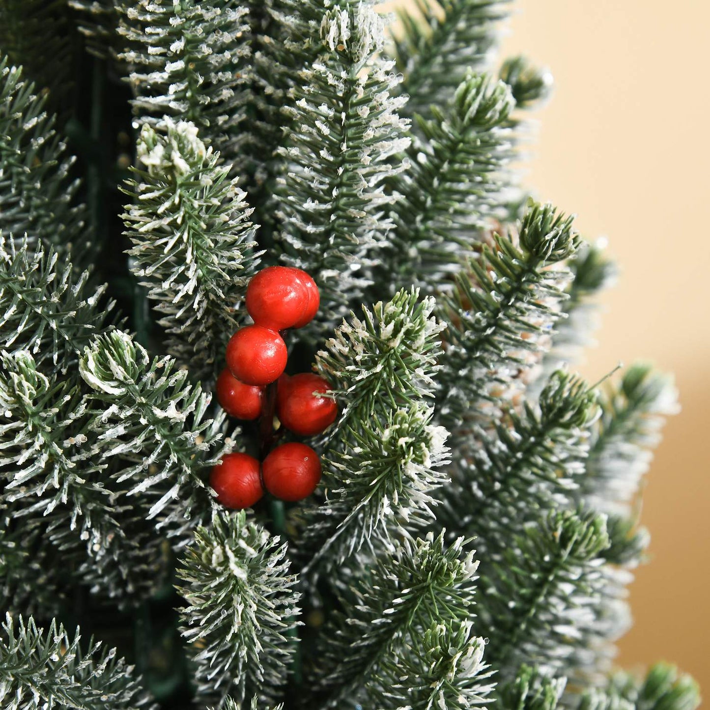 Snow-covered table Christmas tree with berries and pine cones