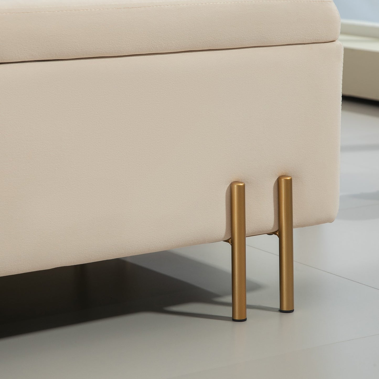 Beige velvet covered storage bench with wooden legs